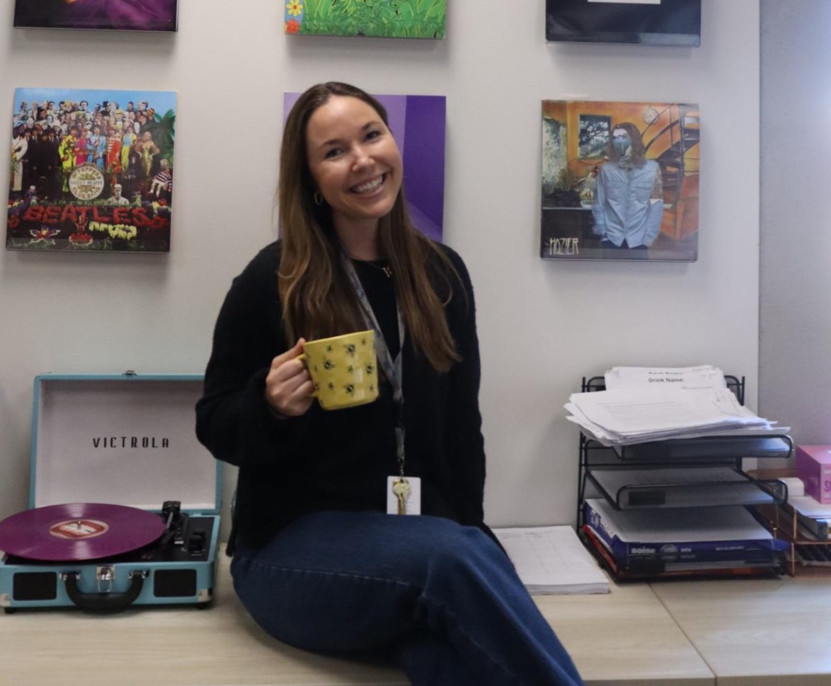 Teresa Barnes sits in front of her collection of vinyls. Barnes joined the school as an Intro to Business and Marketing teacher this year. 