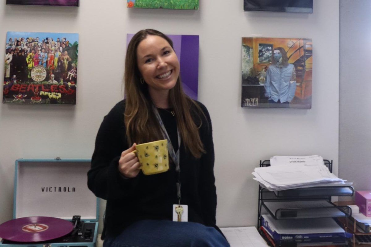 Teresa Barnes sits in front of her collection of vinyls. Barnes joined the school as an Intro to Business and Marketing teacher this year. 