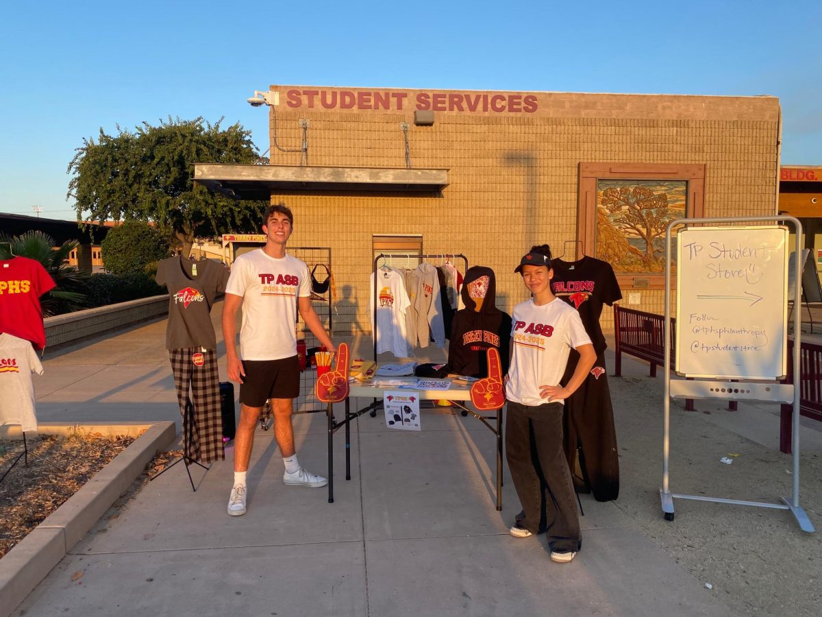 ASB Commissioners' of Sales Ava HeSchenk (11, right) and Tyler Suhar (11, left) advertise merchandise from the student store on Back to School Night. They worked to provide trendy and fashionable merchandise to students at the school. Photo courtesy of Ava HeSchenk.