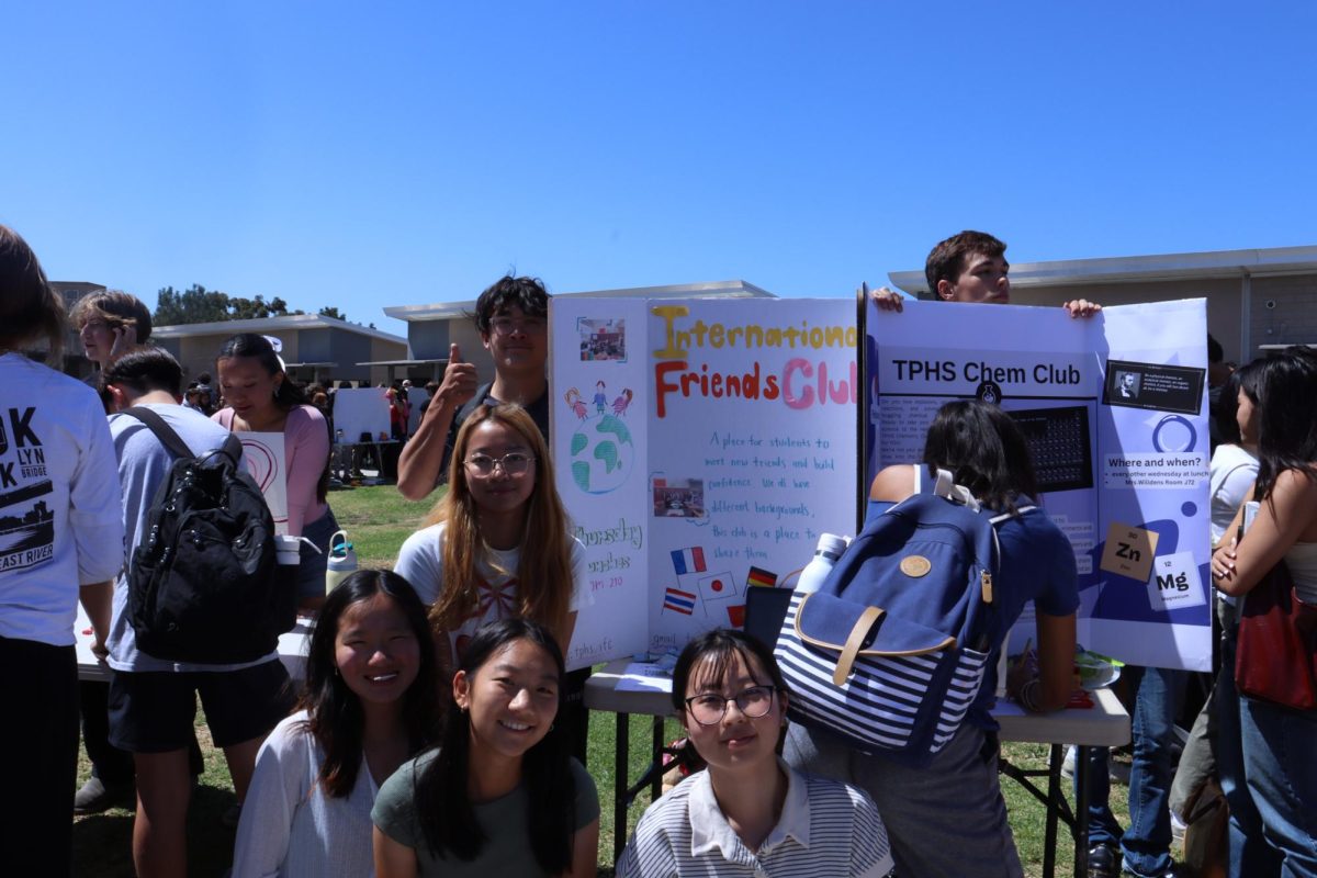 Officers of a club smile at their booth. The International Friends Club aims to provide a place for students of different backgrounds to build confidence and connections. Left to Right: Pratch Maneerat (12), Bomin Kim (12), Carol Chen (12), April Kato (12). 