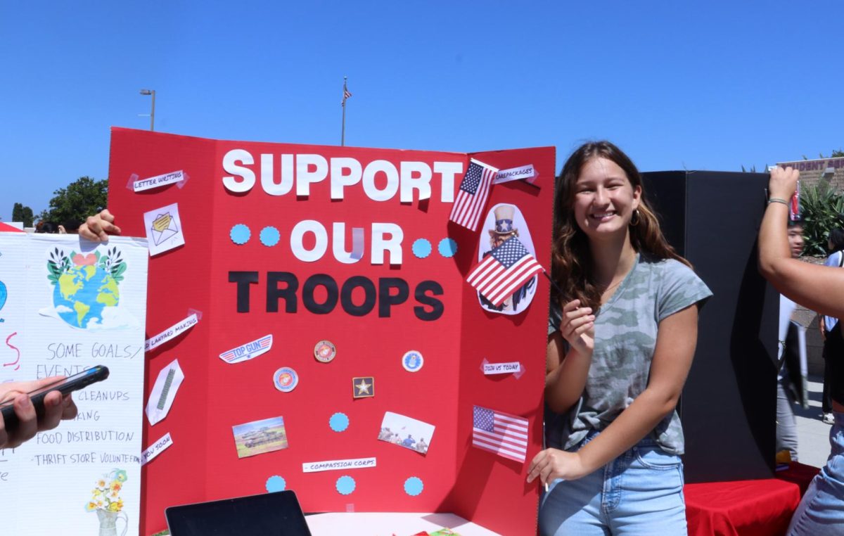 Sylvia Olson (12) is the president of Support Our Troops, where members write letters to deployed military troops. The club passed out small American flags to visitors.