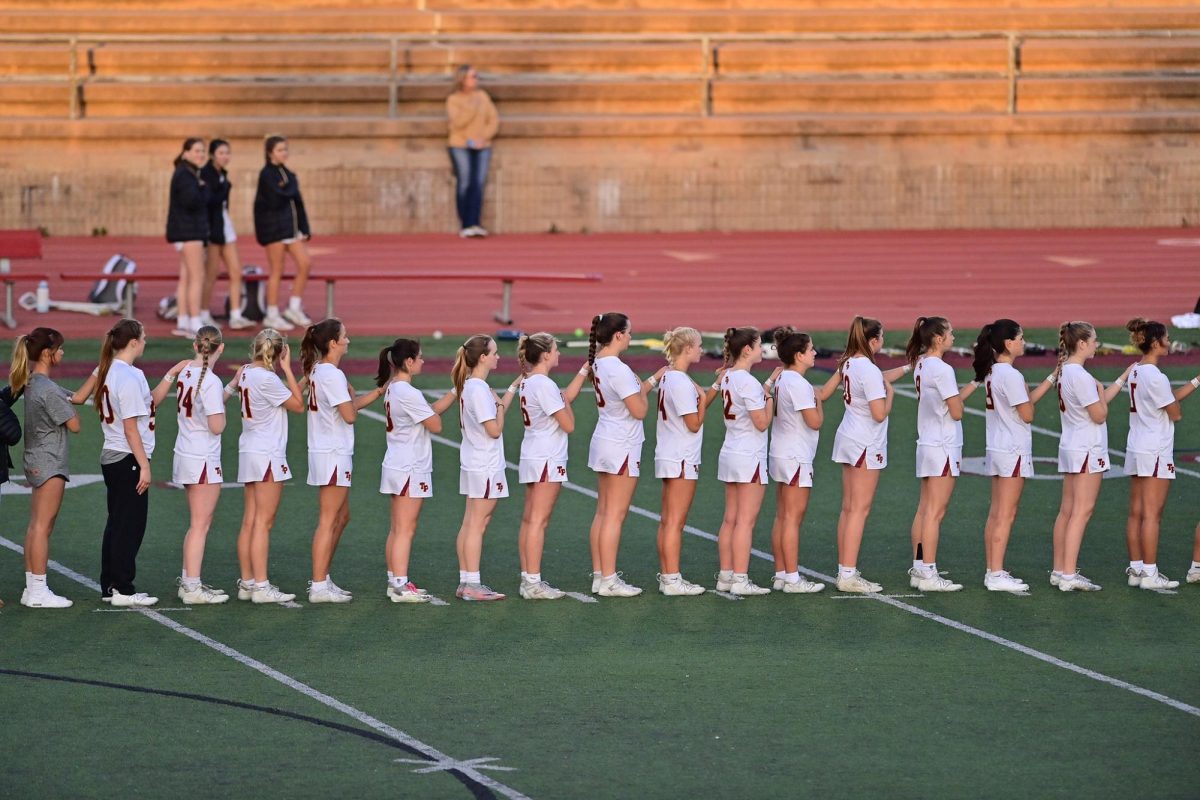 The varsity girls lacrosse team wears wrist tape with a smily face and a special message on game days. Last season, the team also made baskets and posters for Senior Night. Photo courtesy of Anna Scipione.