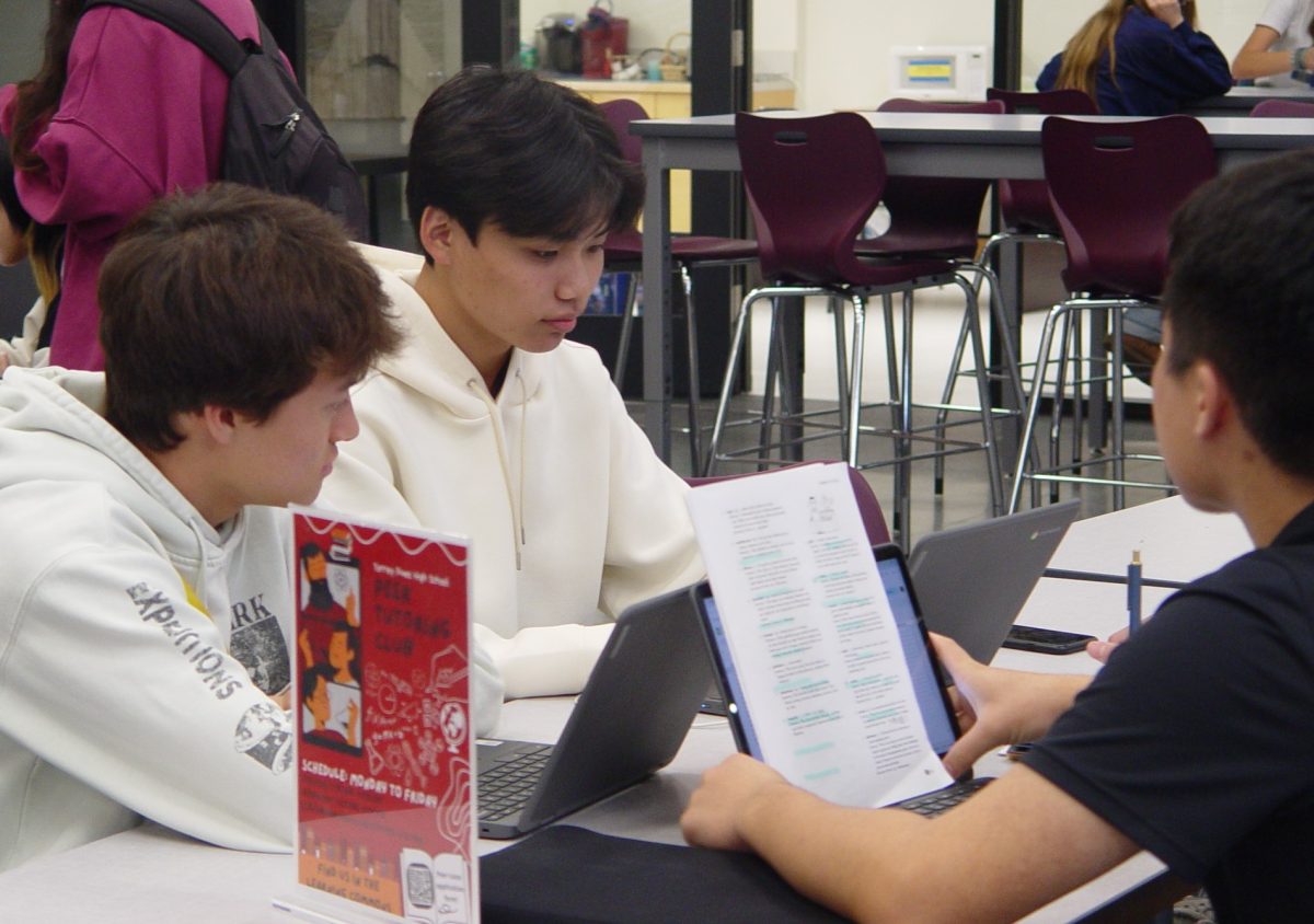 Peer tutors Daniel Schwabach (12) and Yuta Hakozaki (12), and Peer Tutoring Club president Kei Tashiro (12) gather at their table. After the last bell rang, they set up the table with chromebooks and papers, ready to assist students with tutoring sessions. 