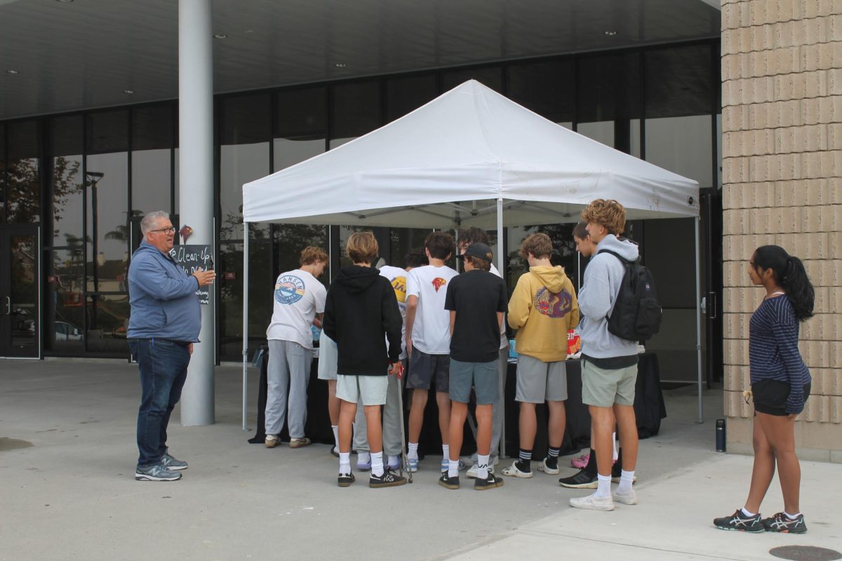 Volunteers line up in front of the foundation tent to sign in and check out tools. The campus cleanup was held from 9 a.m. to 12 p.m. on Oct. 12.