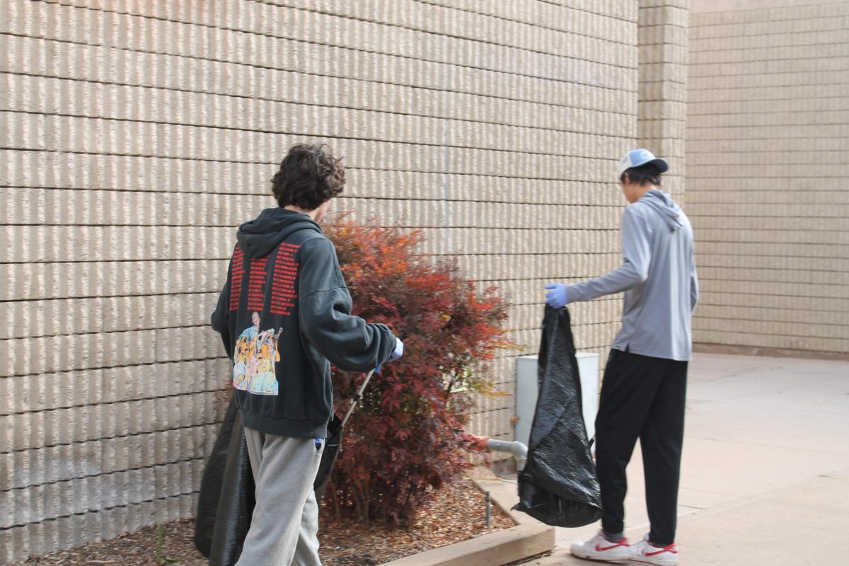 Student volunteers pick up trash and weeds in front of the lecture hall. With trash grabbers and garbage bags in hand, participants roamed around the campus, looking for areas that need most attention. Left to right: Cole Campbell (10) and Gavin Henry (10).