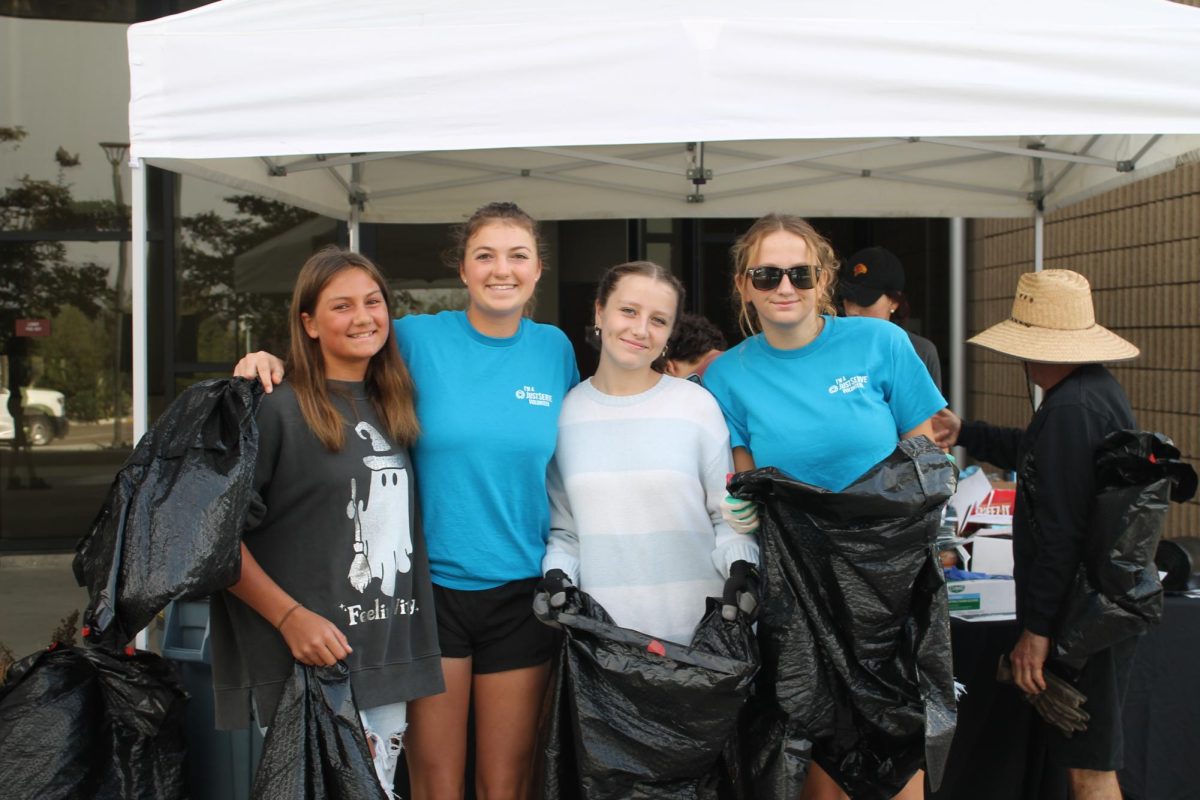 Members of the JustServe club pose at the check-in booth. The event was open for student organizations like clubs and sport teams to participate. Left to right: Lucy Conover, Elizabeth Conover (12), Cordelia Erikson (11) and Chloe Kuemmerle (11).