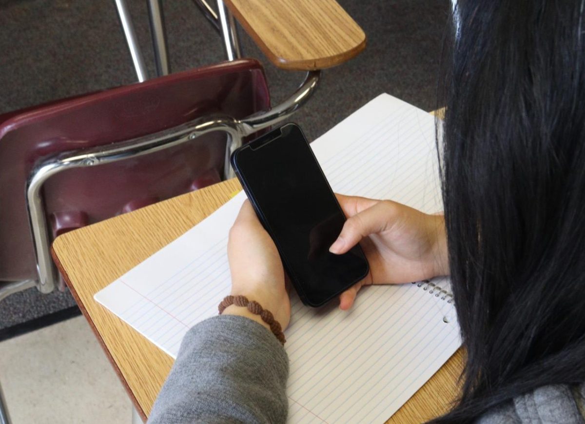 A student goes on their smartphone instead of working on schoolwork. Governor Gavin Newsom signed the Phone-Free Schools Act on Sept. 23, which requires all California school districts to create and adopt a policy that limits or prohibits smartphone use.