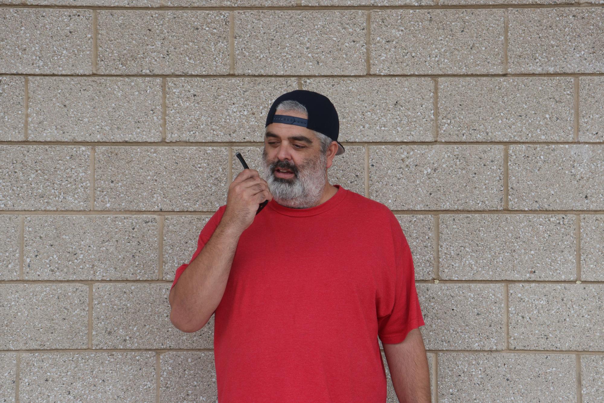 Campus supervisor Jose Reynoso speaks into a walkie-talkie. Reynoso started working at the school six years ago. 