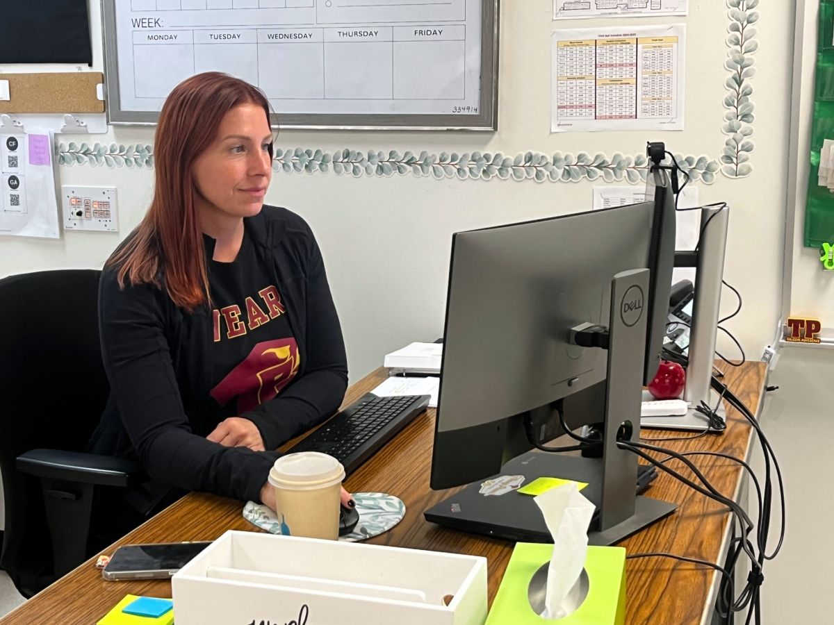 Special education teacher, Jessica Arroyo, checks her computer during passing period, a cup of coffee resting on her desk. Arroyo began her journey in education over a decade ago and worked within the Poway Unified School District before this year. 