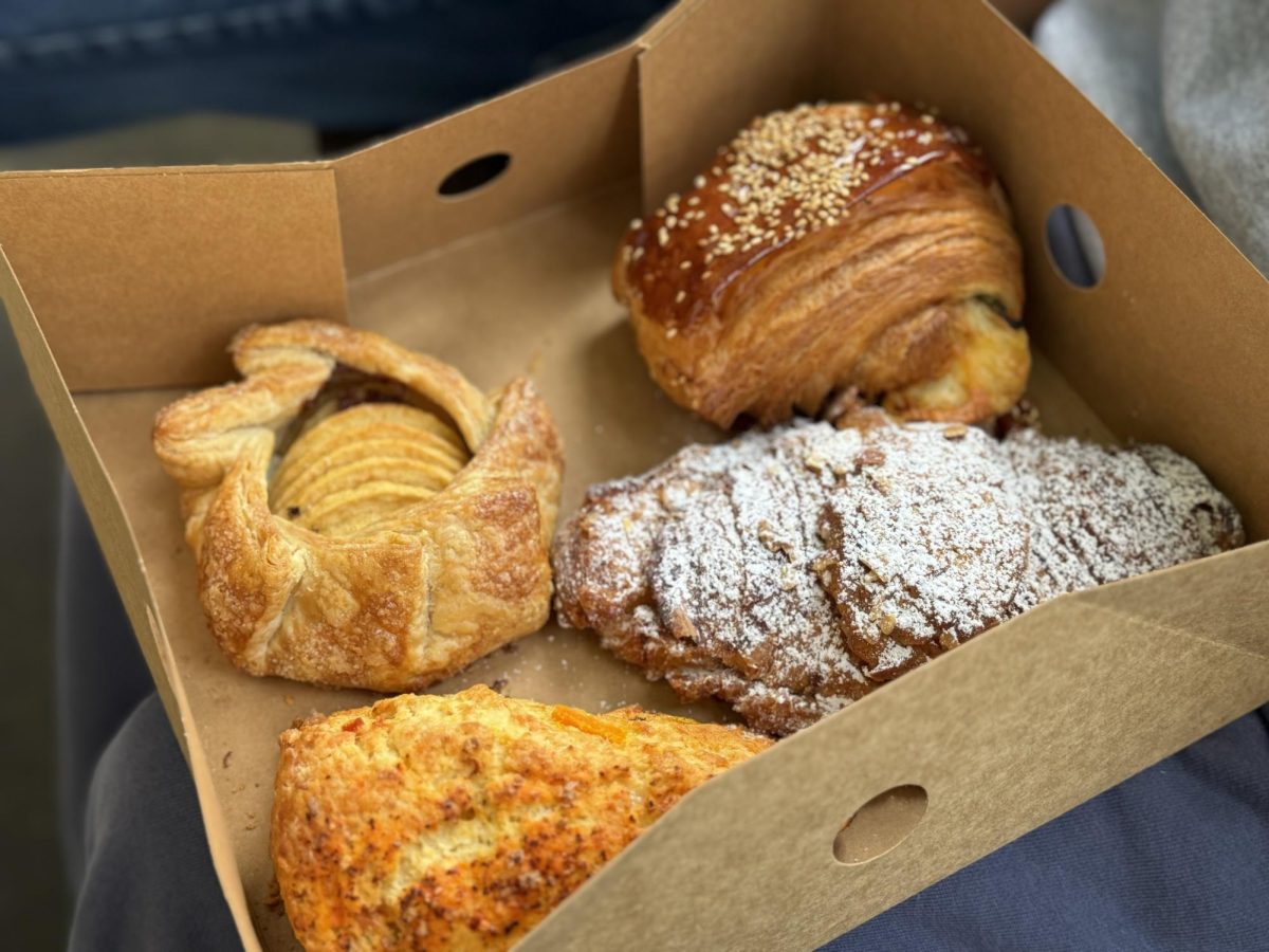 Apple Galette (top left), Jalapeño Fontina Croissant (top right), Savory Butternut Squash Scone (bottom left) and an Almond Croissant (bottom right) from Wayfarer Bread sit in a to-go box. In November, their menu consists of Savory Butternut Squash Scone and Apple Galette among other seasonal pastries.