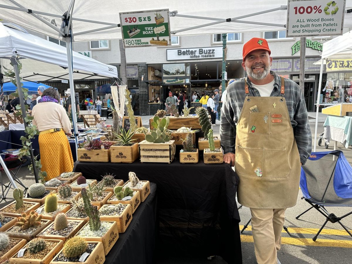 Carlos Smith, co-owner of The Rustic Succulent poses by his tent. Smith started this business with his daughter during the COVID-19 pandemic.