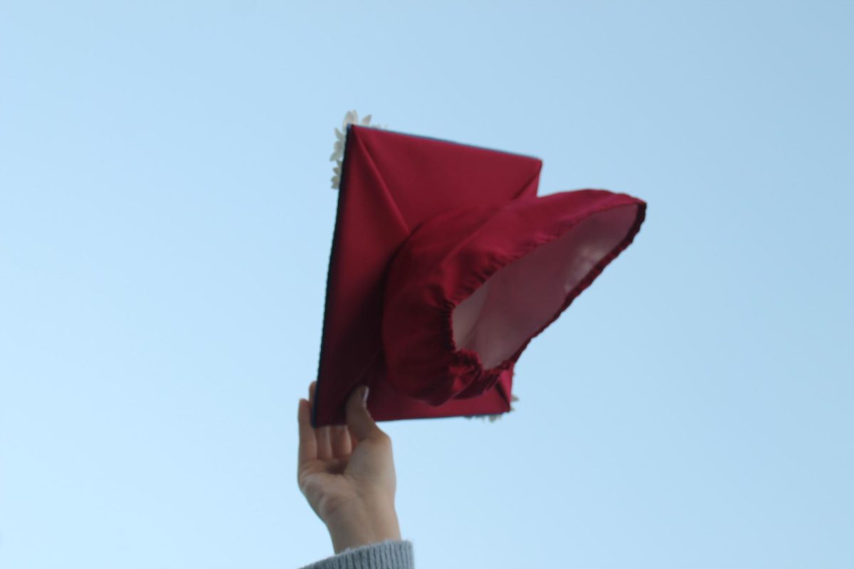 A bright cardinal graduation cap flies into the air. Graduated high school students, like Jocelyn Kim ('23), entered a different dynamic of student life in college. 