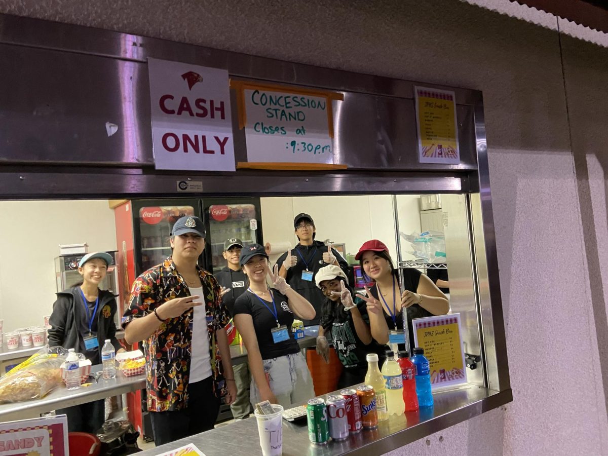 The Japanese National Honor Society poses for a photo during their shift at the concession stands. While the school's Academic Team and JNHS primarily took on the role this year, the opportunity will be more widely promoted to other student organizations starting next school year. Photo courtesy of Kylie Lai.