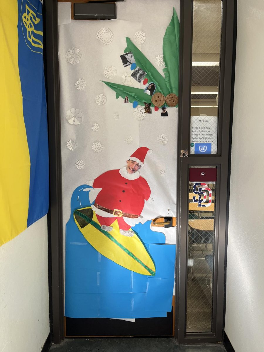 U.S. History teacher and girls golf coach Chris Drake's door shows Santa Claus surfing. Drake's photo is pasted into the face of Santa, surrounded by paper snowflakes.