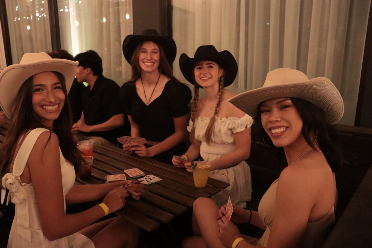 A group of students, dressed in semi-formal attire and western hats, smile for a picture. The theme for the Winter Formal was 'Night In Nashville.' Left to right: Lina Jamai (11), Sienna Barry (11), Alisa Galkina (11) and Ava HeSchenk (11).