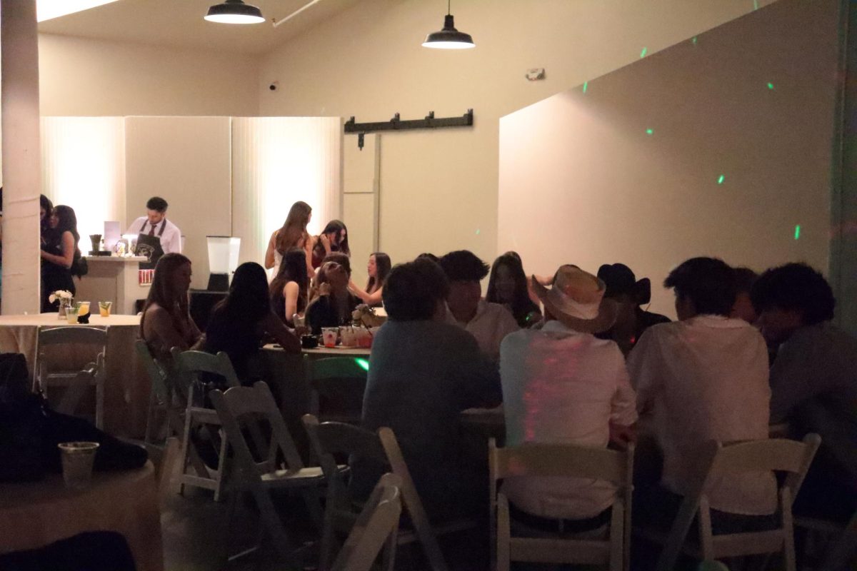 Students gather around the tables near the dance floor. Alongside food, drinks and music, students enjoyed each other's company. 