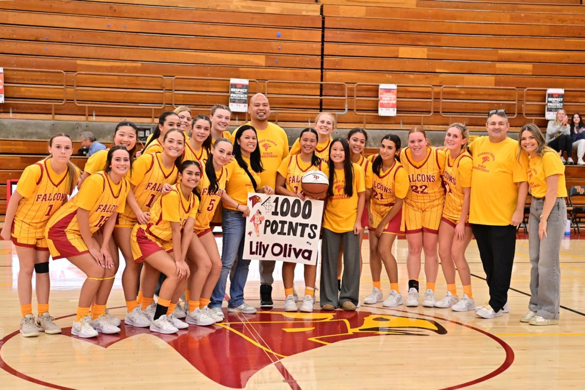 The team celebrates point guard Lily Oliva (12)'s 1,000th career point. Oliva was awarded a basketball and a team trip to Chipotle post-game.