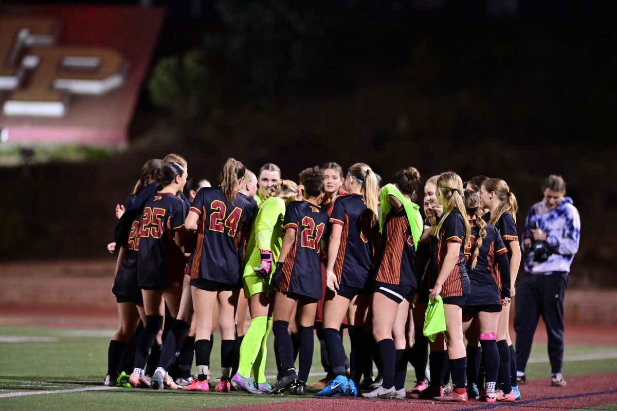 The Lady Falcons huddle up for their cheer before their first league game at home. The girls varsity soccer team (4-3) beat Canyon Crest Academy (1-9) last night after a score of 5-0. Photo courtesy of Anna Scipione. 