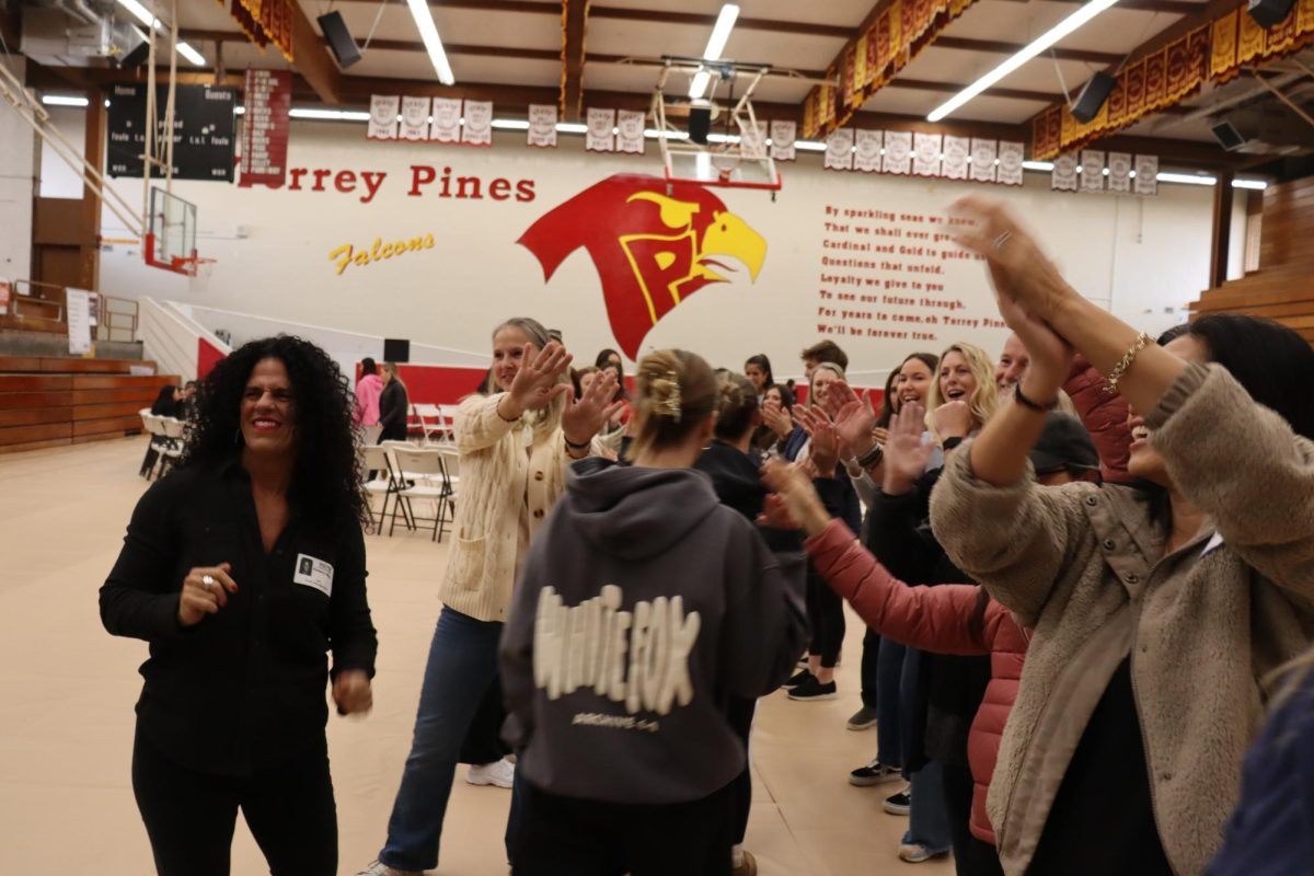 Students receive applause as they enter the gymnasium. Teachers and parent volunteers welcomed the participants with high-fives.