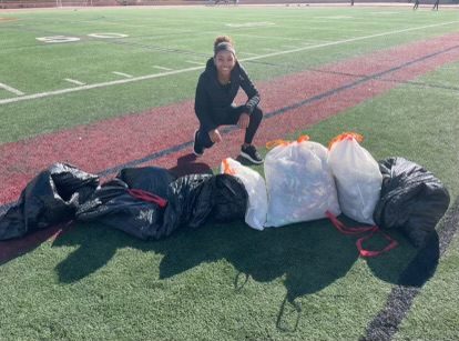 McKenzie Brown smiles near the bags of trash collected during the fundraiser dedicated to the Belle Castle Primary and Infant School in Jamaica. While still garnering donations through GoFundMe, the event took place on Jan. 3. Photo courtesy of McKenzie Brown.