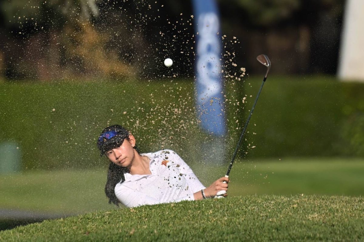 Zoe Jiamanukoonkit (11) watches her ball fly out of the bunker. Jiamanukoonkit was named the November female Athlete of the Month. Photo courtesy of Zoe Jiamanukoonkit.