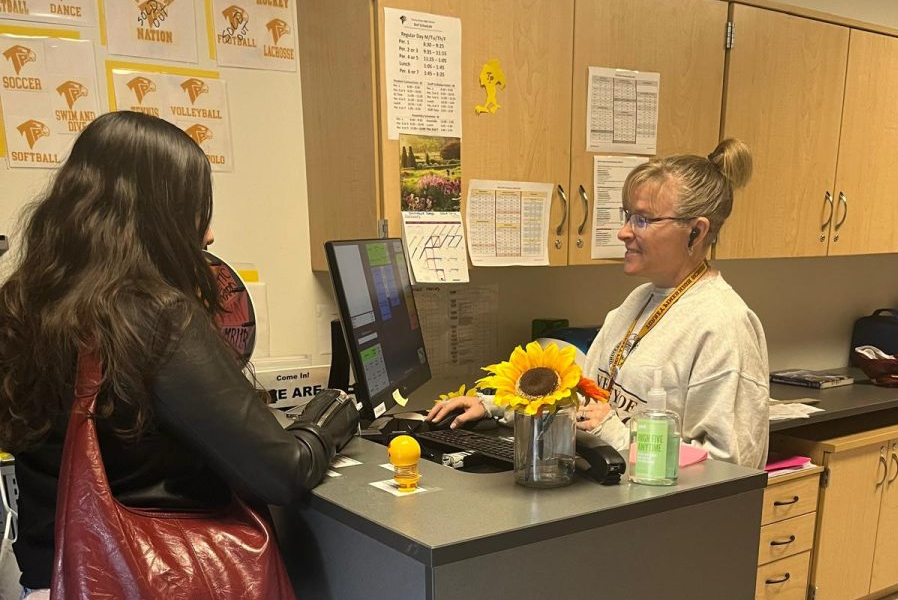 Wearing student attire for staff dress up day, ASB Accounting Assistant Heather Dugdale works in the student store. Dugdale arrived at the store before 8 a.m. to set up and assist students.