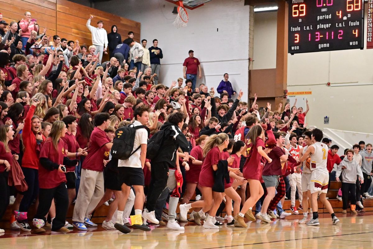 Cardinal Choas rushes the court as the Falcons secure their sixth consecutive win at home. Karel Novy (12) sank the game winning shot in overtime, leaving the team with a final score of 69-68. Photo courtesy of Anna Scipione.