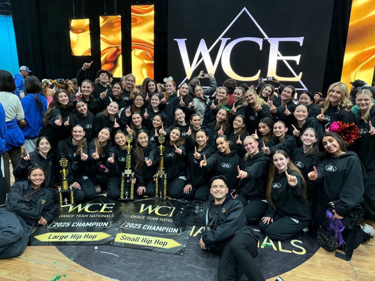 Holding up a finger to celebrate first place,  the dance team smiles in unison at the West Coast Elite Nationals in Palm Springs. The competition was held from March 14-16, with the team bringing home multiple first places. Photo courtesy of Francis Florendo. 