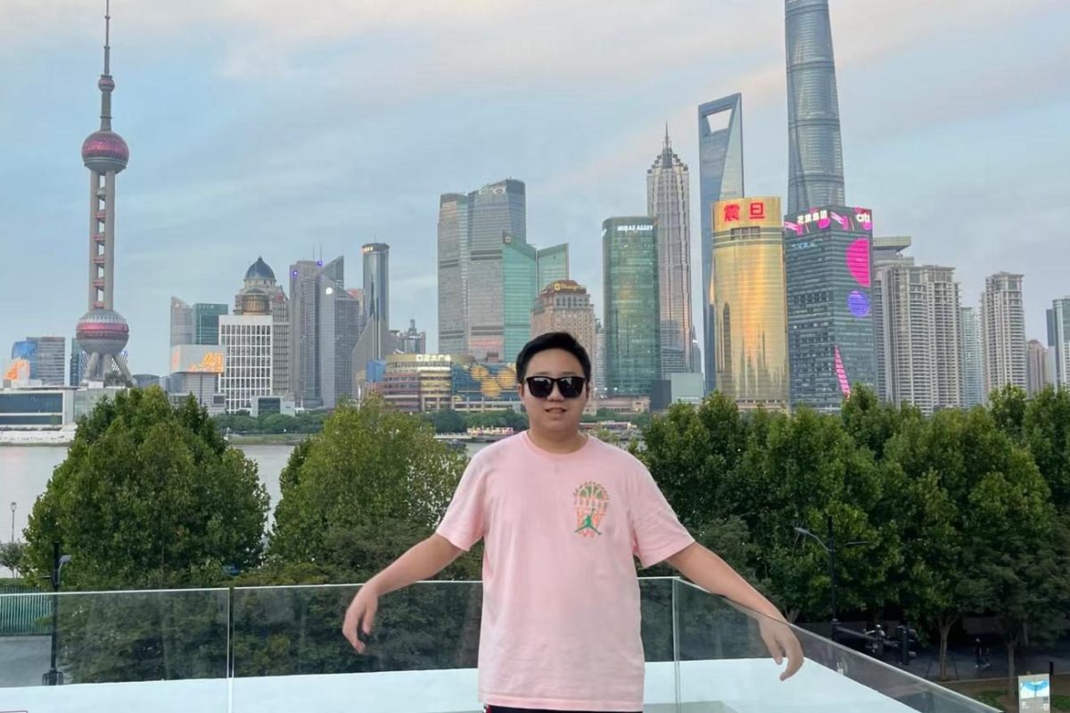 The towering skyscrapers of Shanghai, China rise behind Kimi Lu (10) as he smiles in front of the Oriental Pearl TV Tower. The photo was taken the summer before he moved to the United States. Photo courtesy of Kimi Lu. 