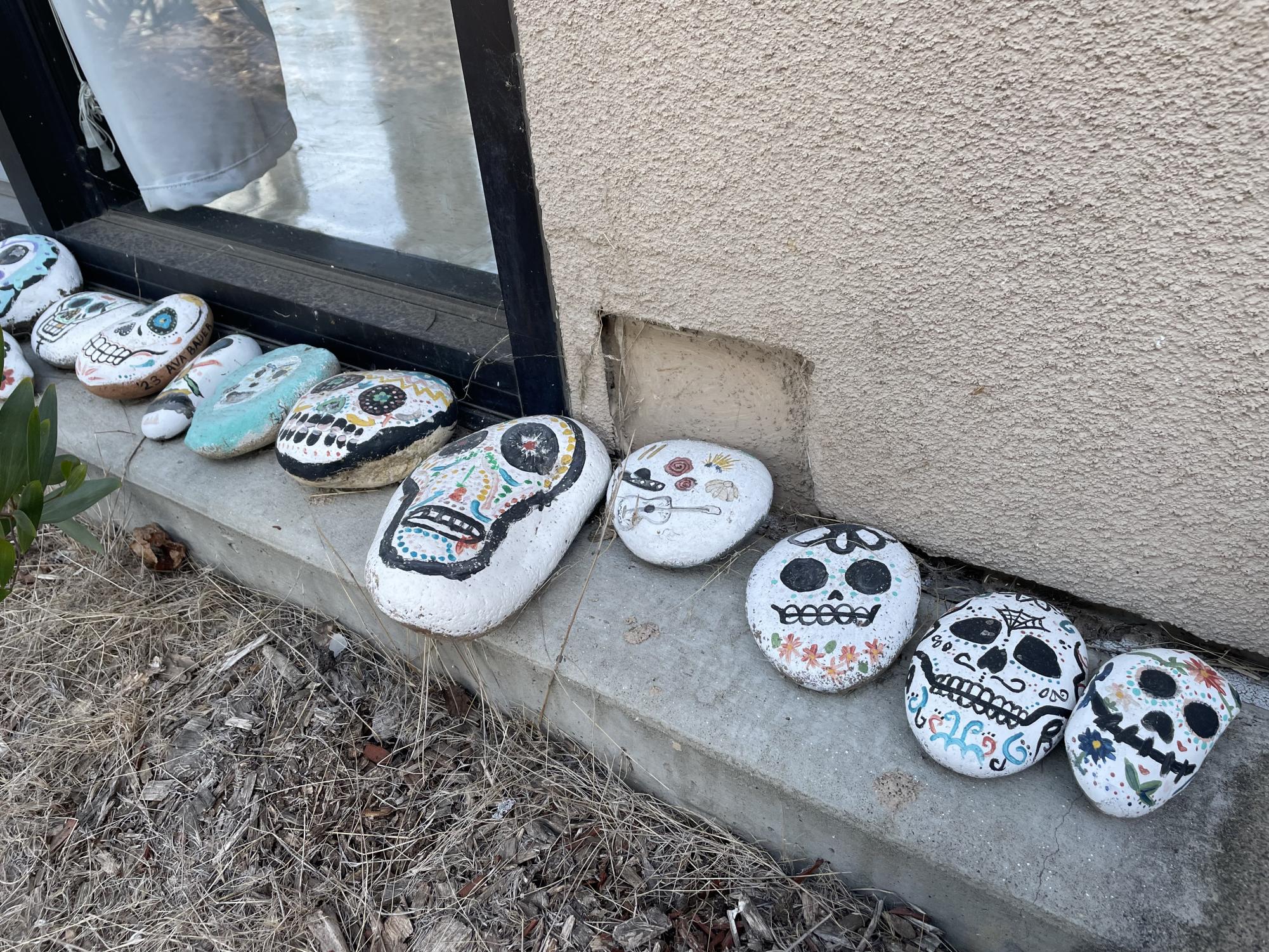 Painted rocks line the curb outside Spanish 4 and AP Spanish teacher Viviana Alvarado's classroom. Students from past years painted the rocks, which depicted calaveras, or sugar skills. 