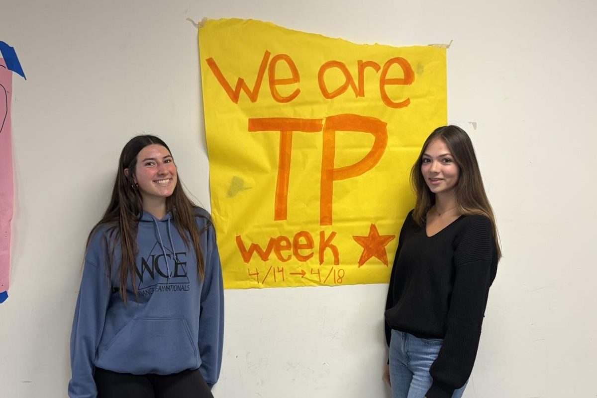 Left to right: ASB Diversity, Equity and Inclusion leaders Bellina Tricarico (10) and Amelia Mazo (10) pose in front of an advertisement for the school's ongoing We Are TP Week. This week, students had the opportunity to take part in a school-wide Kahoot, scavenger hunt, conversation with district officers and participate in the Diversity Fair. Photo courtesy of Bellina Tricarico.