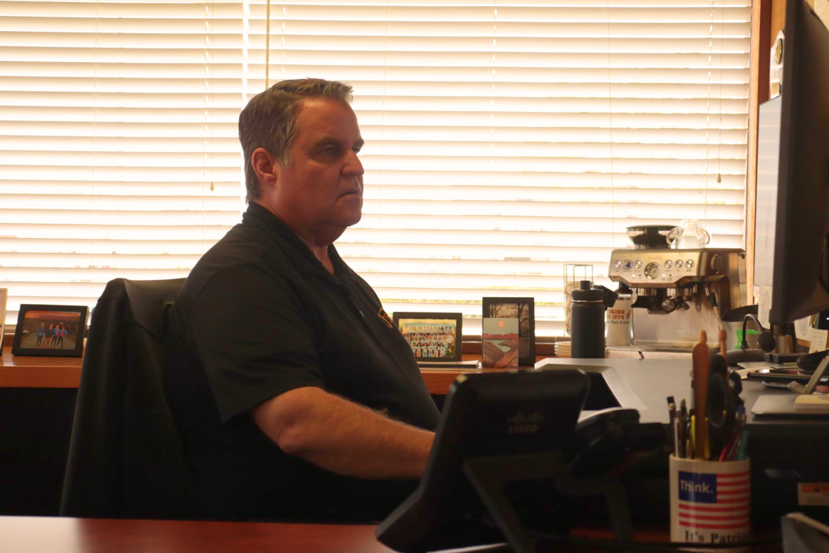 Principal Rob Coppo works at the computer in his office and handles administrative tasks. In addition to his duties as principal, Coppo began hosting a podcast with former teacher Don  Collins in 2023. 