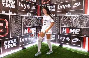 Nami Walsh (11) juggles a soccer ball in her new Brown University uniform at a media shoot. Walsh verbally committed to play Division I soccer on August 11th, 2025. Photo courtesy of Nami Walsh.
