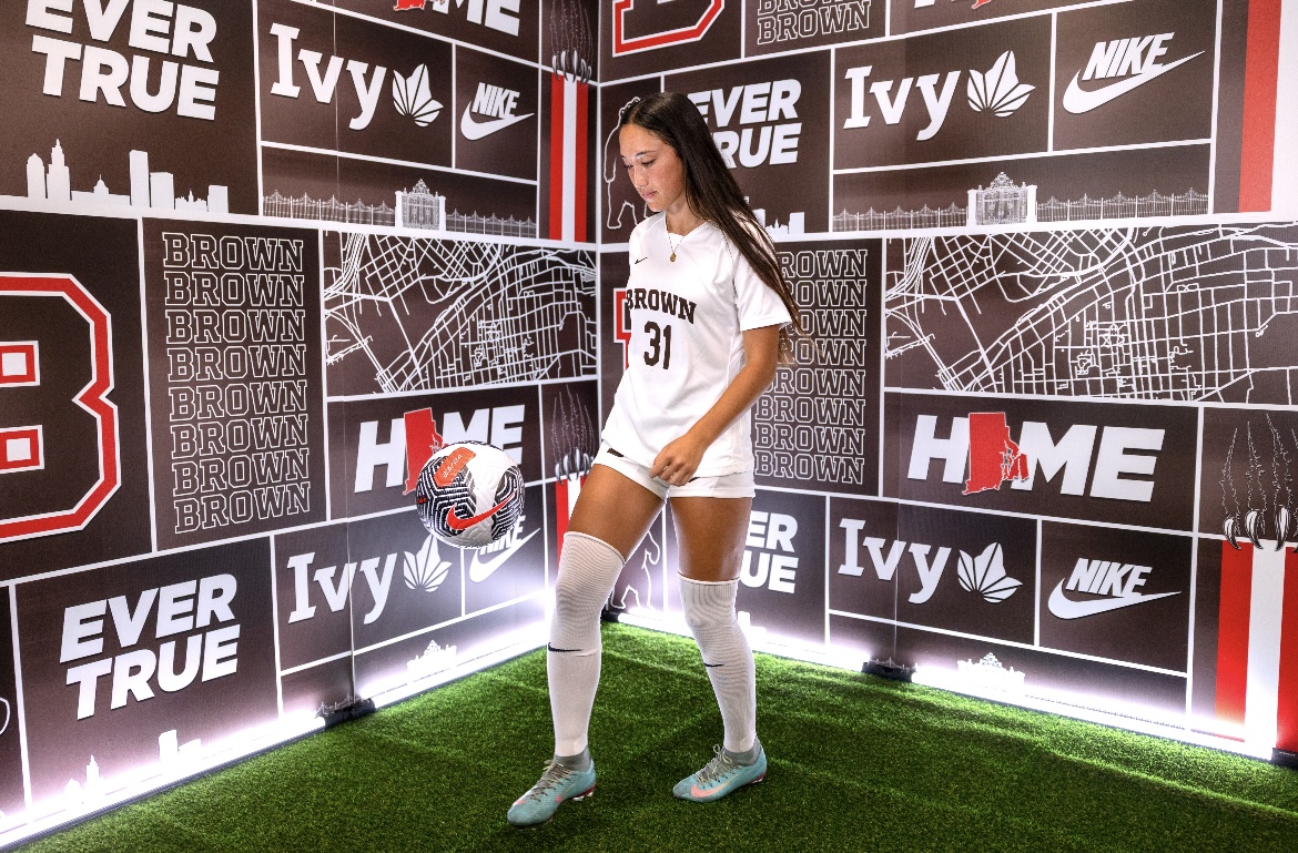 Nami Walsh (11) juggles a soccer ball in her new Brown University uniform at a media shoot. Walsh verbally committed to play Division I soccer on August 11th, 2025. Photo courtesy of Nami Walsh.