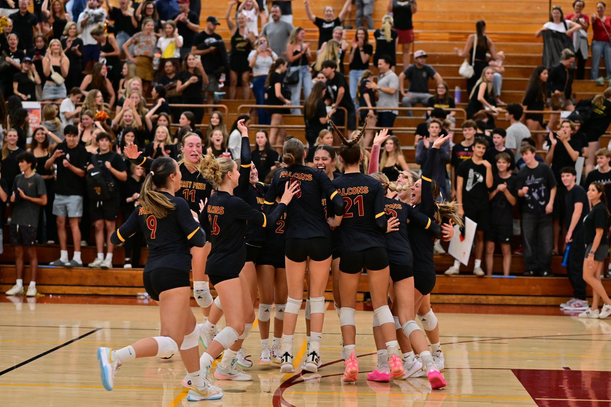 After scoring the final point, the girls' volleyball team rushes together on the court and celebrates their victory. The Falcons beat the Dons (3-0) on Sept. 10 in the Olive Garden. Photo courtesy of Anna Scipone.
