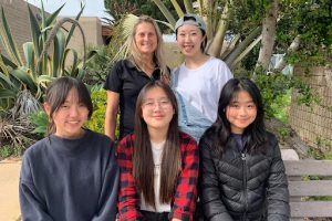 The Falconeers, Jiwon Ryu (12) (top, right), Yewon Jeong (10) (bottom, left), Jaehee Nam (10) (bottom, middle) and Zhixin Chen (11) (bottom, right), smile for a picture with their mentor Julianna Newell (top, left). The group designed a product for Sustainable Goal Development 15: Life on Land. Photo courtesy of Sarah Tsu. 