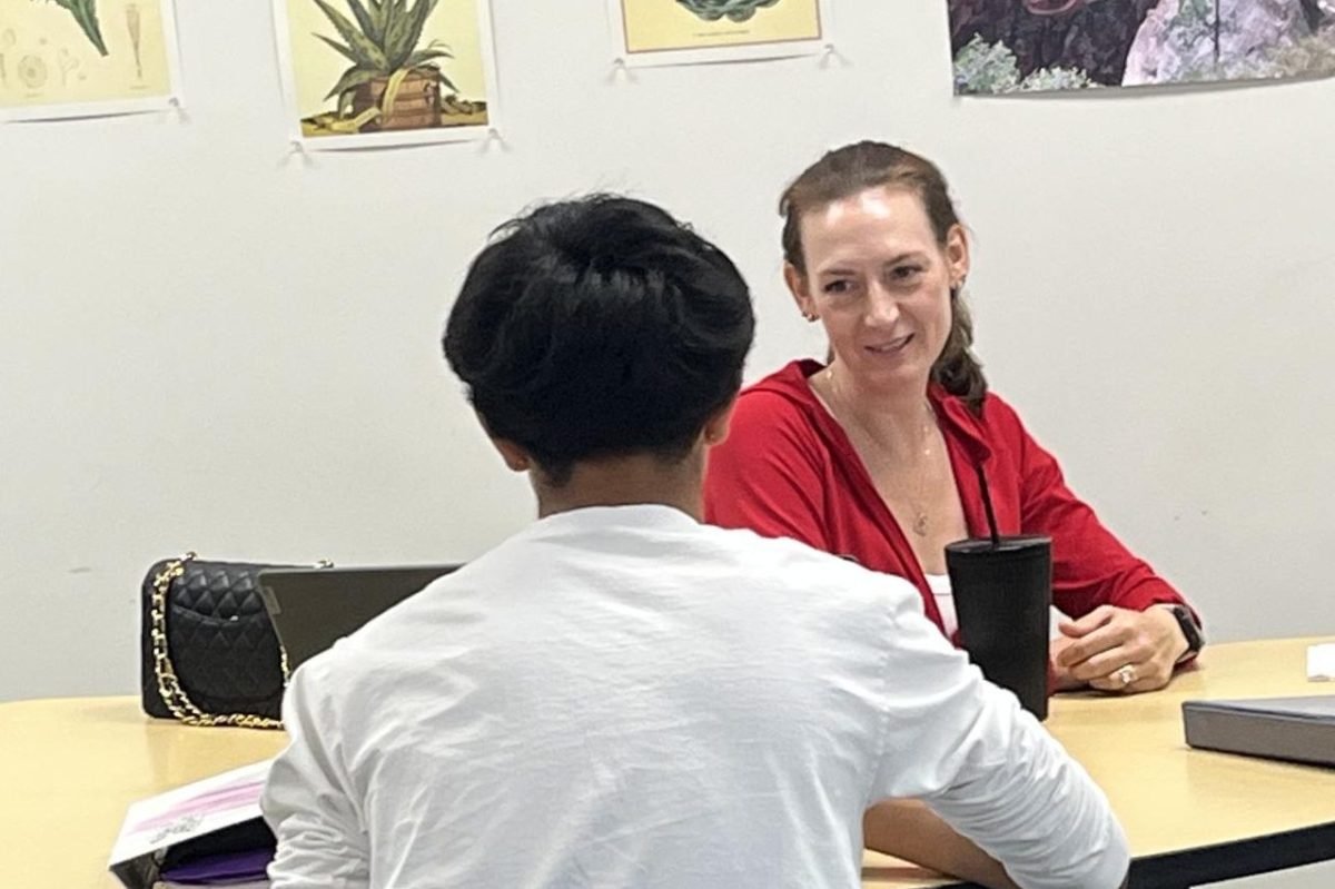 Krommenhoek sits with a student and helps him with his homework. She joined the school this year  after spending the last ten years at Pacific Trails Middle School. 