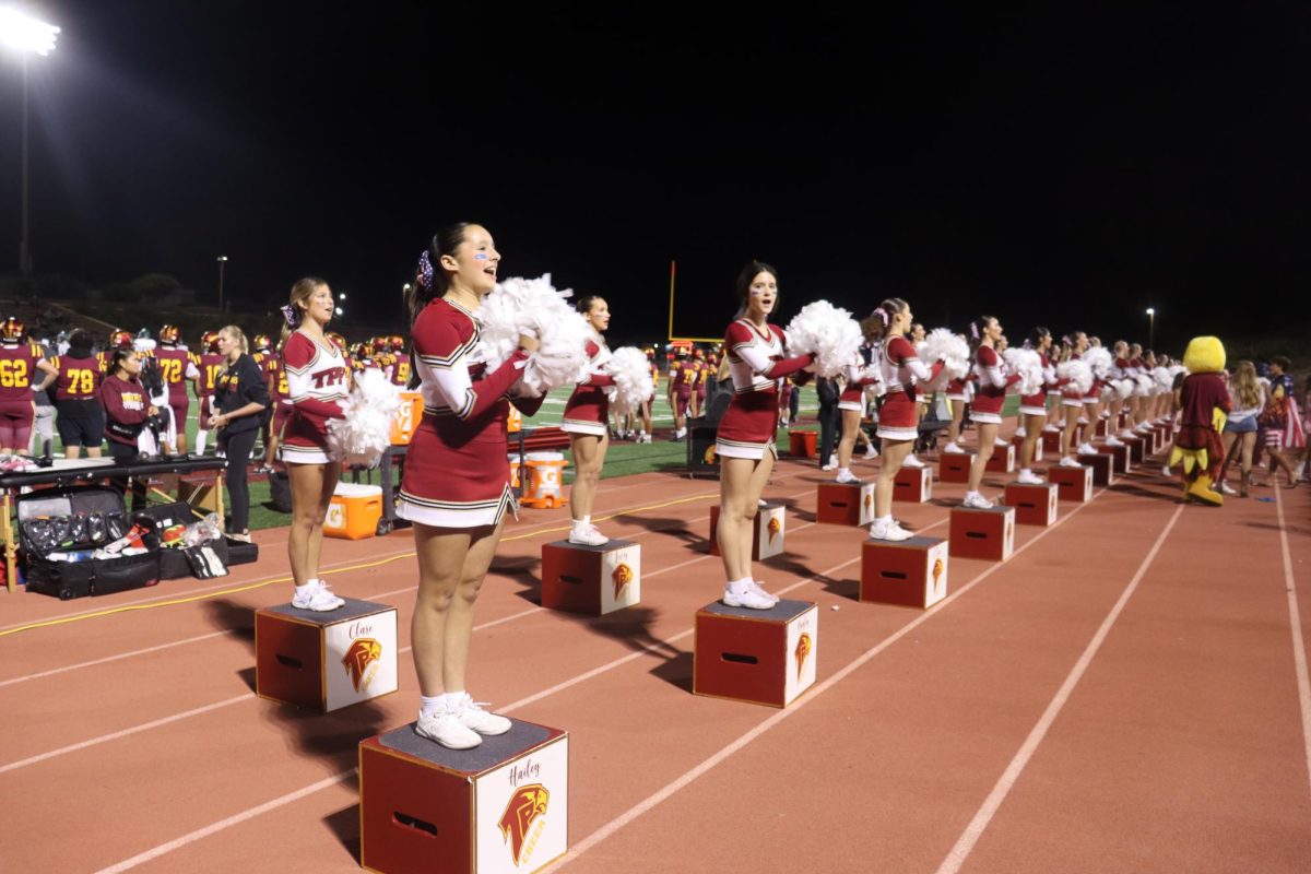 The girls are performing their second-quarter sideline cheers. The cheer team did not stop working throughout the game as they were focused on energizing the crowd.