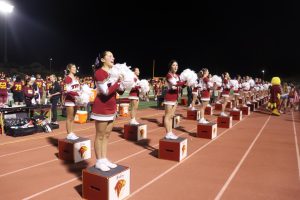 The girls are performing their second-quarter sideline cheers. The cheer team did not stop working throughout the game as they were focused on energizing the crowd.