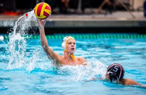 Erik Greene (11) throws the waterpolo ball mid-match to a fellow teammate. Greene started on varsity his freshman year. Photo courtesy of Erik Greene.