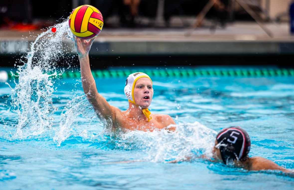Erik Greene (11) throws the waterpolo ball mid-match to a fellow teammate. Greene started on varsity his freshman year. Photo courtesy of Erik Greene.