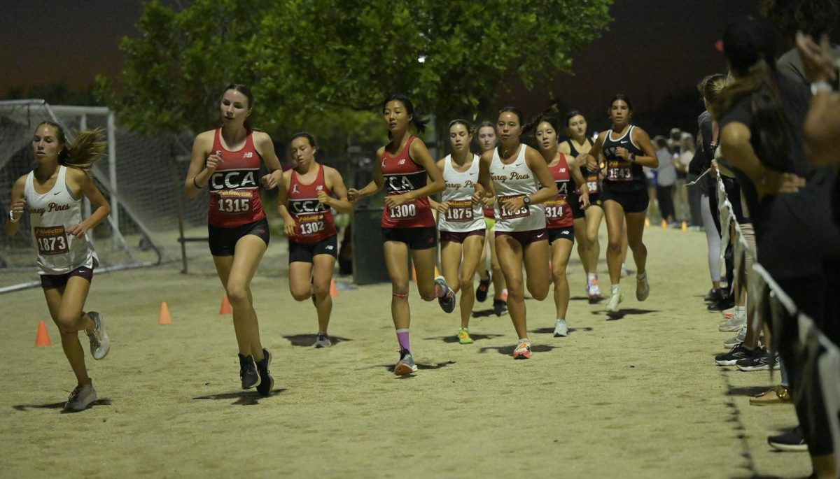 Girls cross country athletes run around the track during their 3 mile coastal varsity race. The team took second in mens and women varsity races at the  The North County Conference Coastal. Photo courtesy of Torrey Pines Cross Country Team.