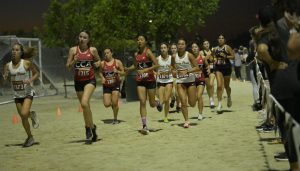 Girls cross country athletes run around the track during their 3 mile coastal varsity race. The team took second in mens and women varsity races at the  The North County Conference Coastal. Photo courtesy of Torrey Pines Cross Country Team.