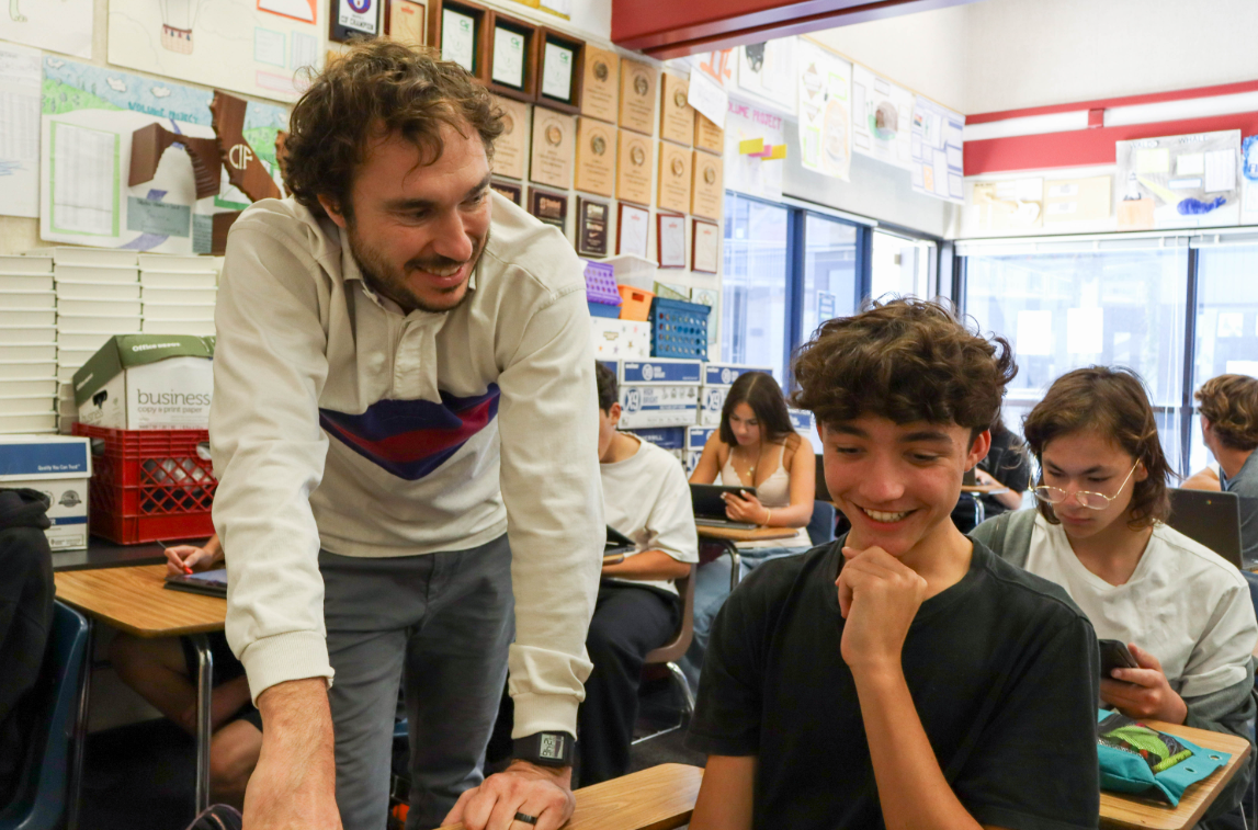 Reed Kendall helps Felipe Astiz (9) with his math worksheet. Kendall joined the math department as a permanent staff member this year. 