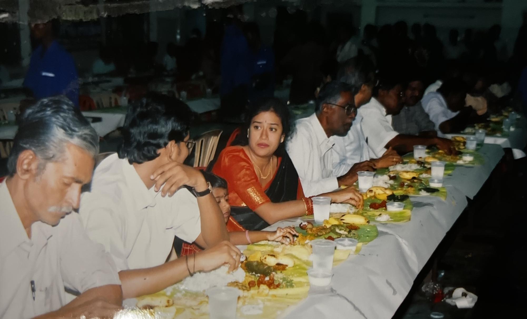 At Iniya Sivakumar's (11) parents' wedding, a row of guests eat with their hands. They ate off of banana leaves as plates. Photo Courtesy of Iniya Sivakumar
