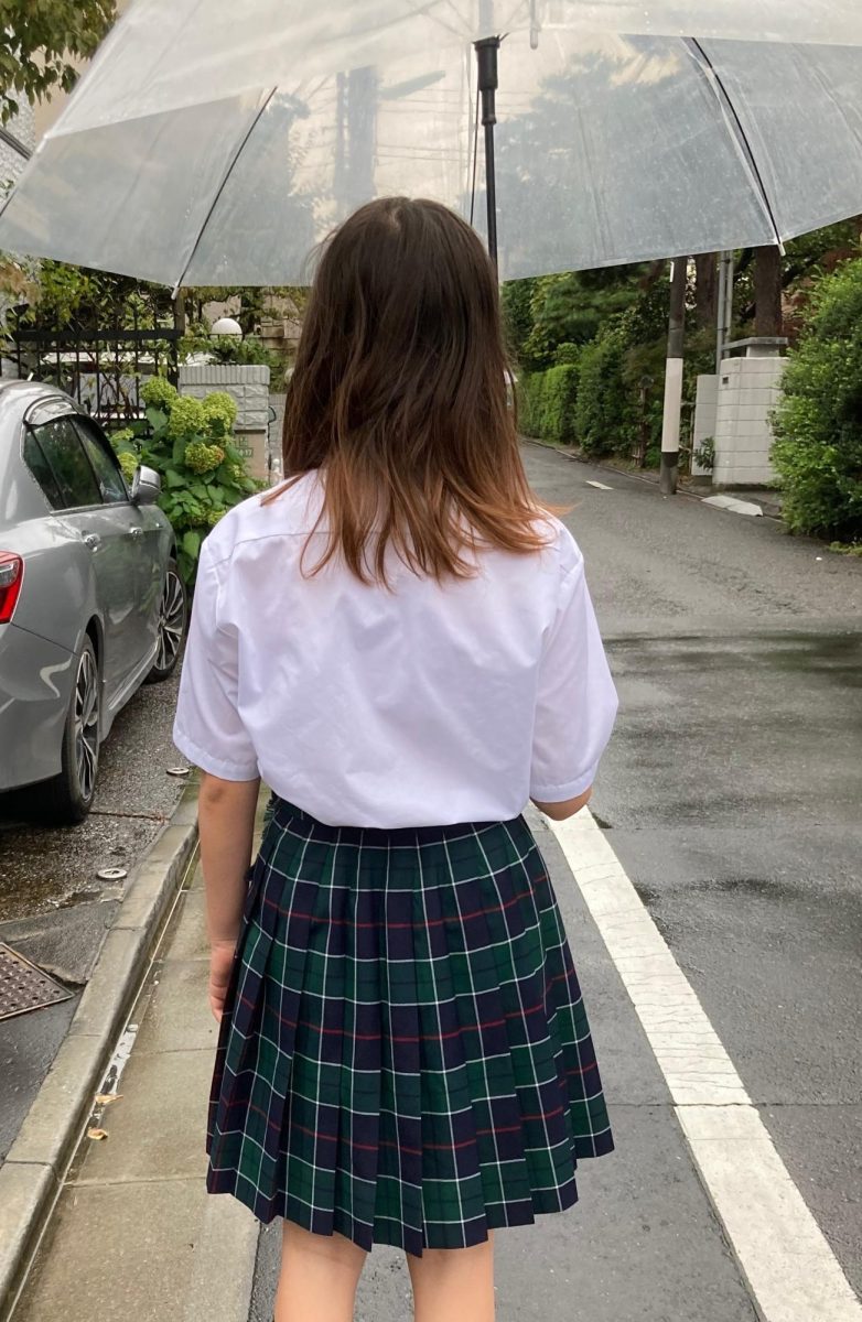 Lana Smallwood (10) walks to her international school in Tokyo wearing her required uniform: a button-up shirt tucked into a plaid skirt. Smallwood found the dress code in the United States to be far less strict than that of Japan. Photo courtesy of Lana Smallwood.