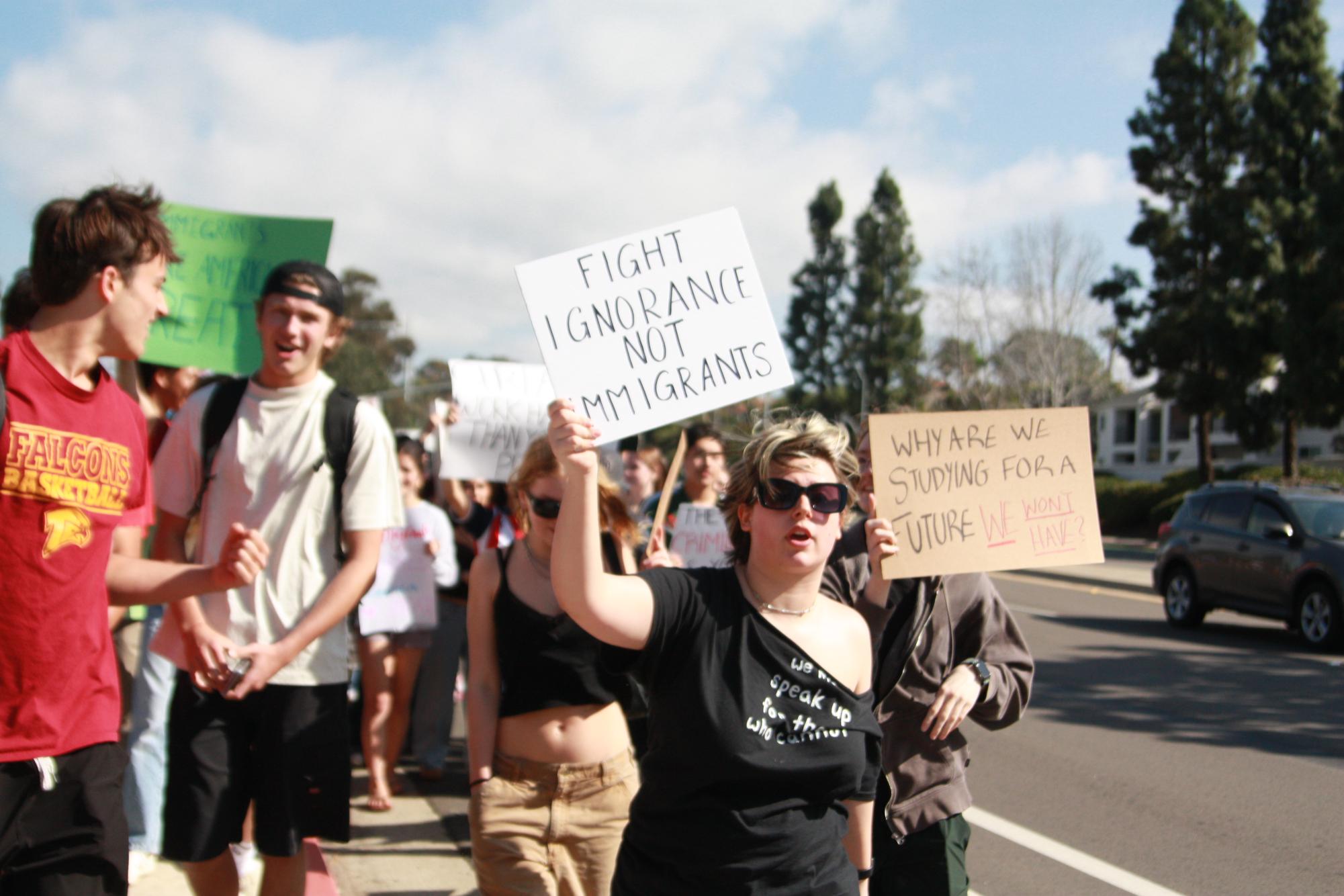 Syd Roenfeldt (11) (right) walks at the front of the crowd. Roenfeldt created the protest route and assisted crowd control as they ushered students off the road and led the initial stretch of the walk.