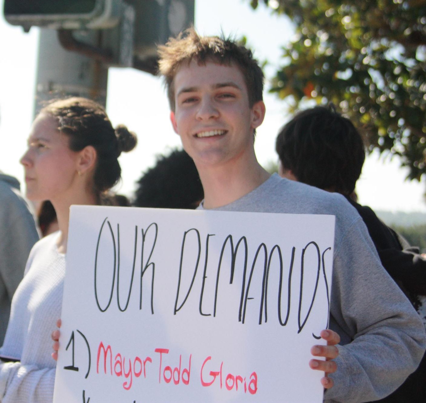 Trey Riddle (11) holds a poster with his three demands. The walkout was on Feb. 6.