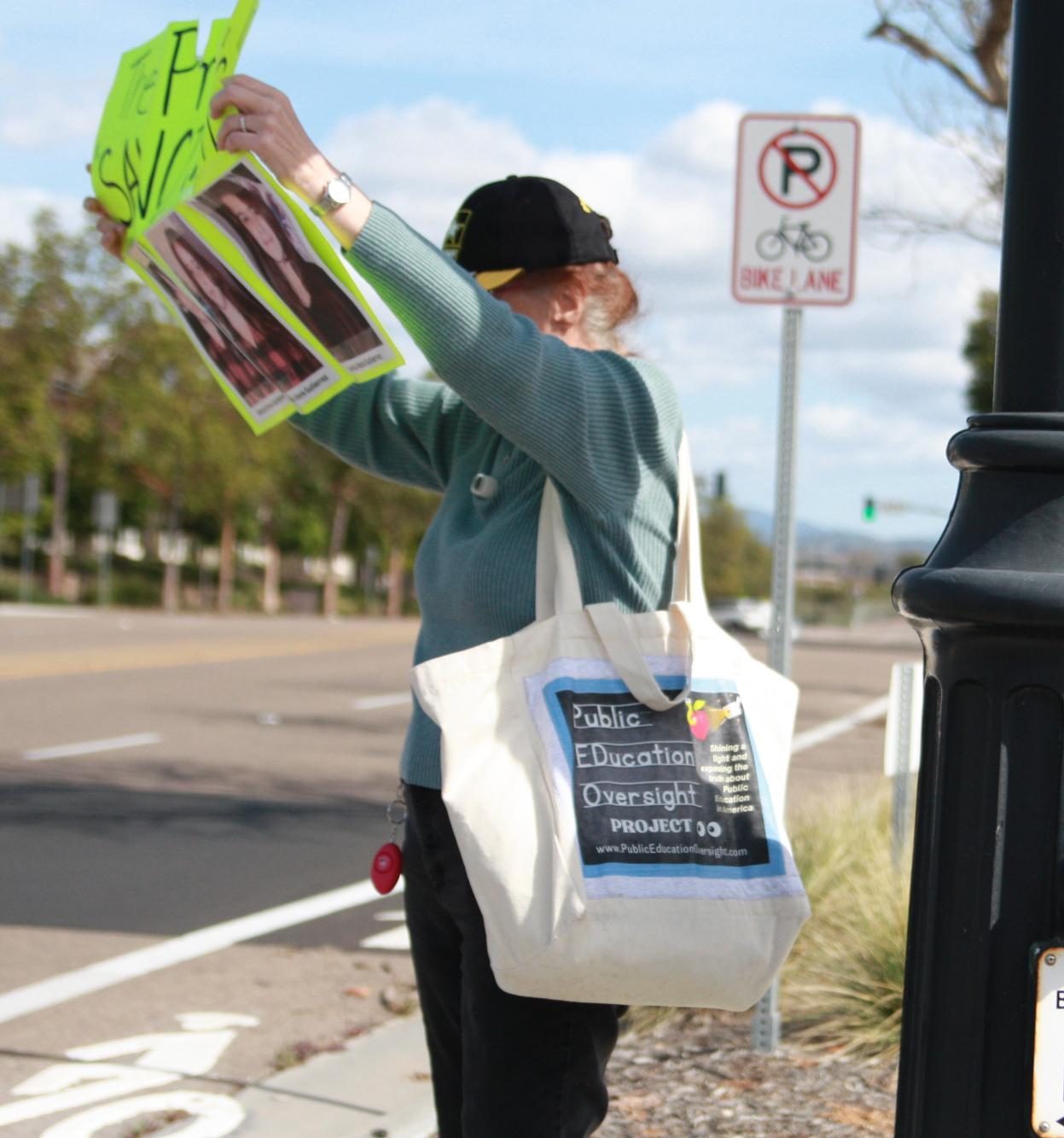Counterprotestor Mary Davis holds up a sign offering a different point of view. Her poster features six dead children, reading: "The price of sanctuary."