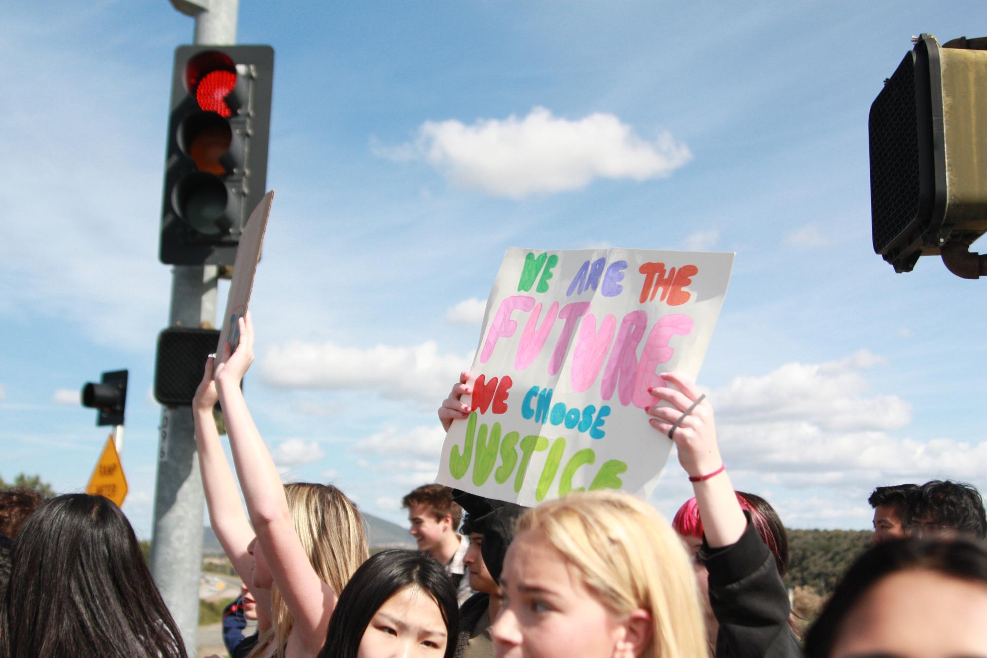 A sign reads: "We are the future, we choose justice." Many protestors prepared pre-made signs.